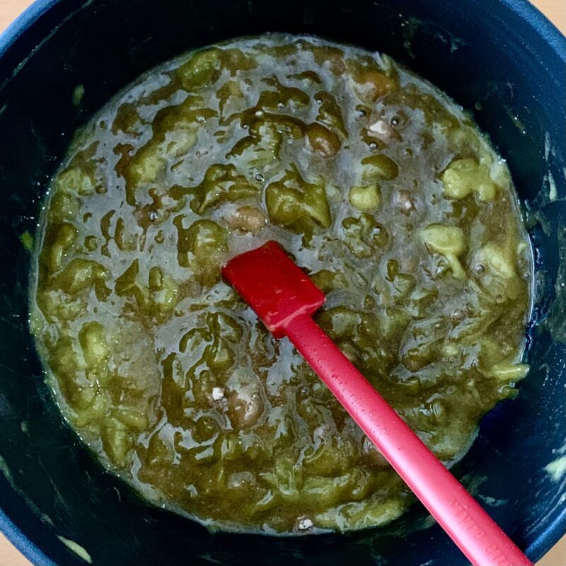 青梅ジャムを鍋の中でかき混ぜながら煮詰めている様子。果肉の質感がしっかり残った手作りジャムの調理風景。